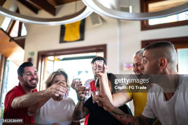 friends drinking shot in a bar - taking a shot - sport imagens e fotografias de stock