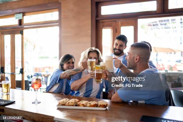 sport team fans doing a celebratory toast in a bar - meal kit stock pictures, royalty-free photos & images