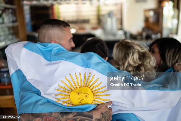 vista posteriore dei tifosi della squadra argentina che guardano una partita in un bar con bandiera argentina - campionato mondiale foto e immagini stock