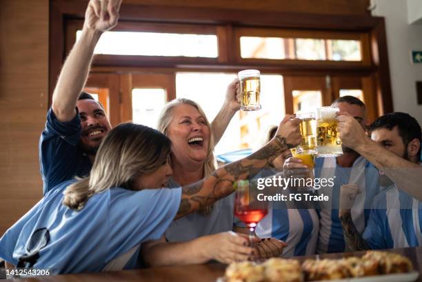 argentinian team fans celebrating while watching a match in a bar - social tv awards stockfoto's en -beelden