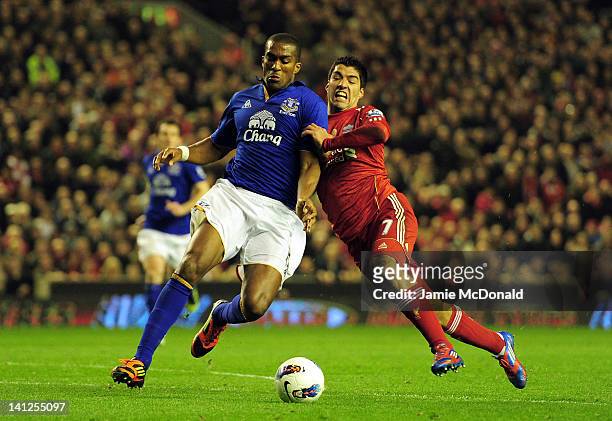 Sylvain Distin of Everton and Luis Suarez of Liverpool battle for the ball during the Barclays Premier League match between Liverpool and Everton at...