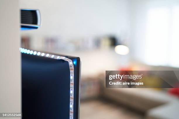 front view of defocused view of modern living room interior with big beige sofa with lots of colorful cushions and illuminated lamp - blurry living room stockfoto's en -beelden