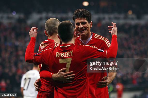 Mario Gomez of Muenchen celebrates his team's sixth goal with team mates Franck Ribery and Arjen Robben during the UEFA Champions League Round of 16...