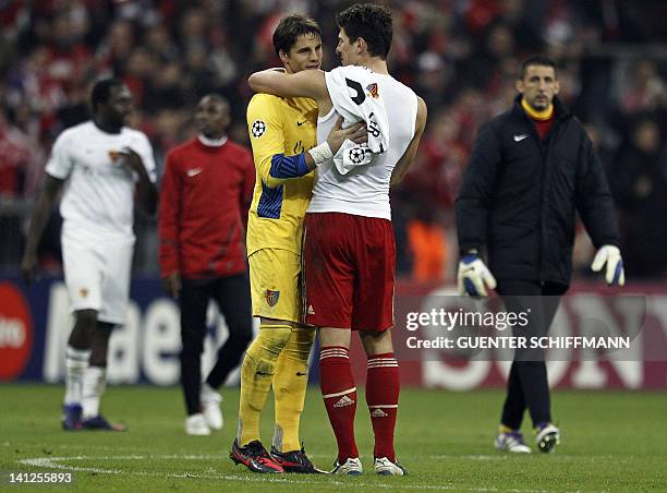 Basel's goalkeeper Yann Sommer is hugged by Bayern Munich's striker Mario Gomez after the UEFA Champions League round of 16 second-leg match of FC...