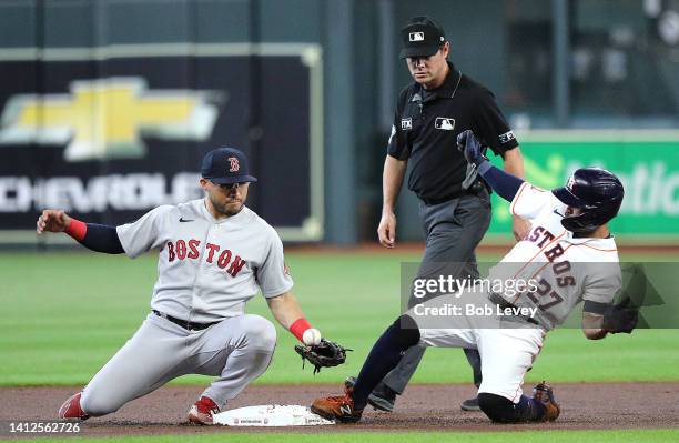 Jose Altuve of the Houston Astros slides into second base with a double as Yolmer Sanchez of the Boston Red Sox bobbles the throw in the first inning...