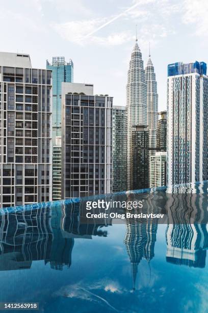 infinity swimming pool on roof of luxury hotel with view of petronas twin towers in kuala lumpur, malaysia - rooftop pool imagens e fotografias de stock