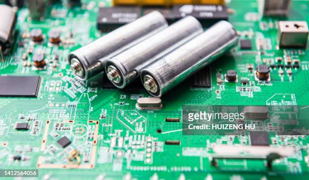 aa batteries on the blue circuit board - alkaline stockfoto's en -beelden
