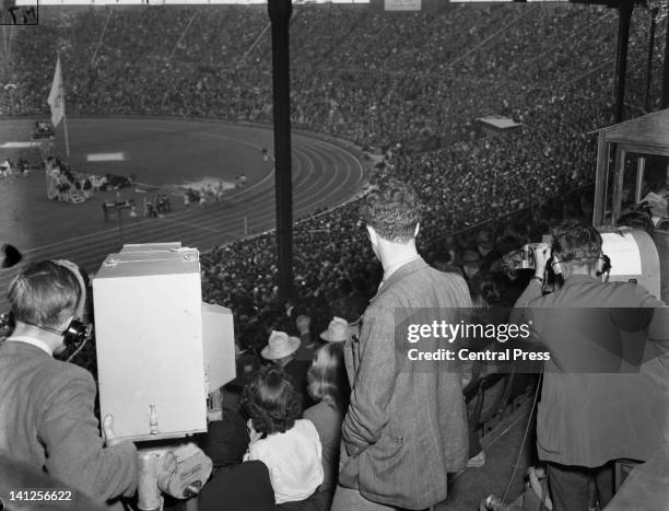 Camera crew tracking round to follow a 1500 metres event at Wembley Stadium during the London Olympics, 4th August 1948.