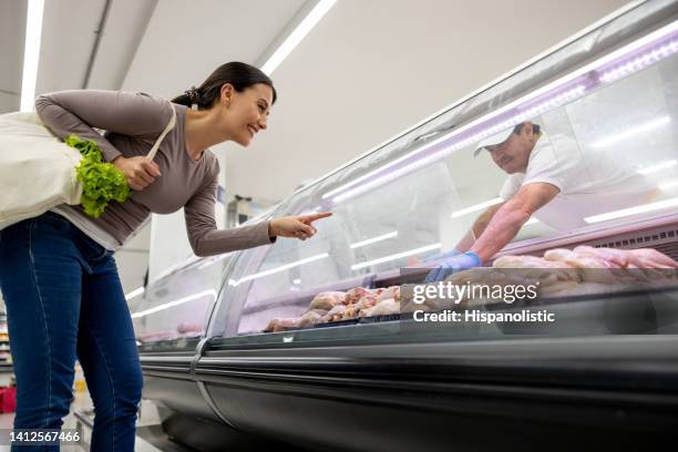 happy woman buying chicken at the supermarket - latin american and hispanic shopping bags stock pictures, royalty-free photos & images