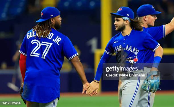 Vladimir Guerrero Jr. #27 and Bo Bichette of the Toronto Blue Jays celebrate after winning a game against the Tampa Bay Rays at Tropicana Field on...