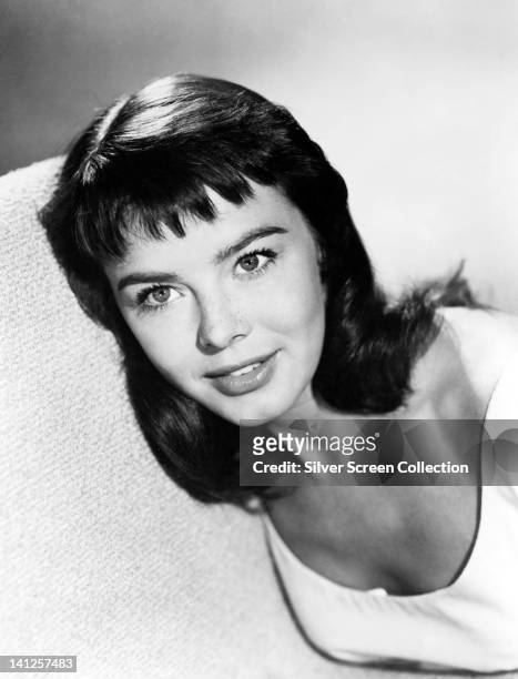 Janet Munro , British actress, wearing a white top with a scoop neckline in a studio portrait, circa 1965.