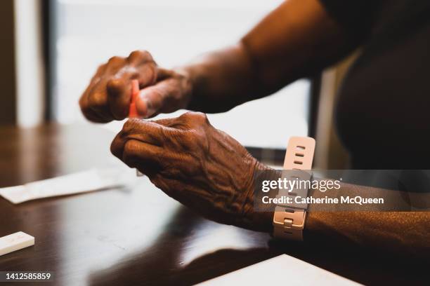 black woman takes at-home covid-19 test - preventive care stock pictures, royalty-free photos & images