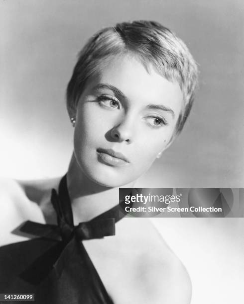 Headshot of Jean Seberg , US actress, her eyes glancing to the right of the image, wearing a black halterneck top in a studio portrait, against a...