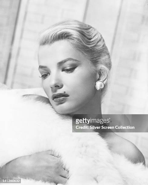 Gena Rowlands, US actress, wrapped in white fur in a studio portrait, circa 1955.