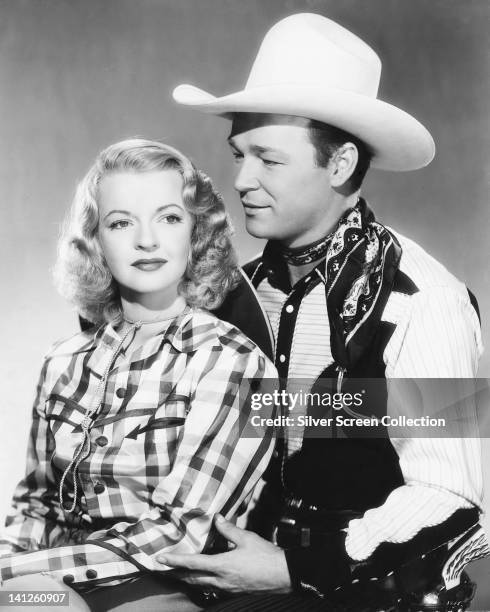 Dale Evans , US actress and singer, wearing a plaid shirt, and her husband, Roy Rogers , US actor and singer, wearing a white cowboy hat, neckerchief...