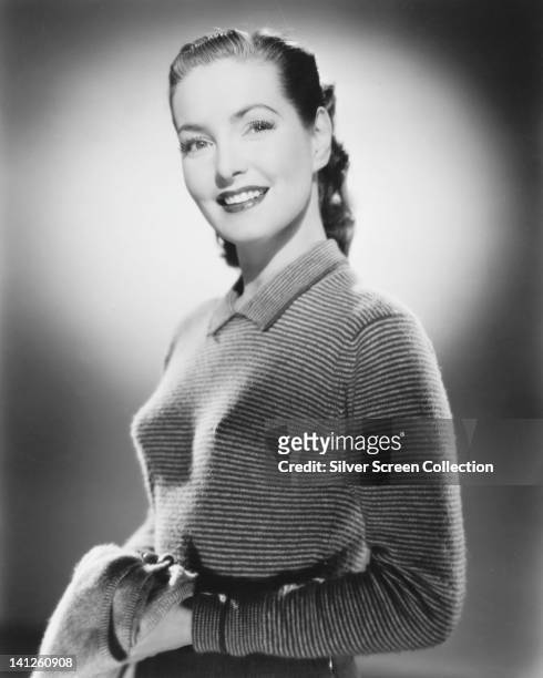 Patricia Roc , British actress, wearing a long sleeve top with horizontal stripes, smiling in a studio portrait, circa 1945.