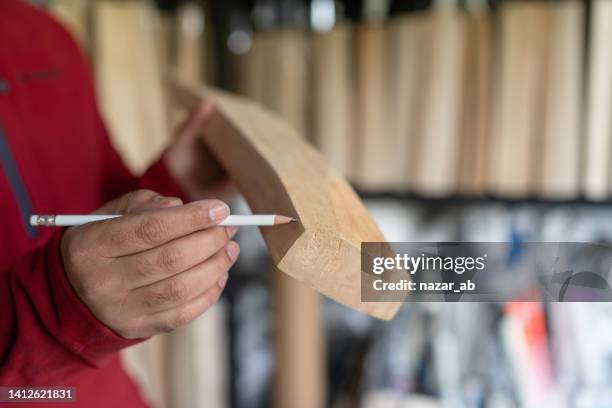 human hand holding pencil marking on wooden bat. - cricket bat stock pictures, royalty-free photos & images