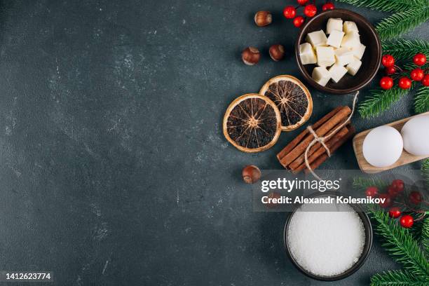 holiday bakery ingredients - butter, eggs, sugar, cinnamon and holiday decoration on dark blue table. top view, copy space - food photography dark background blue imagens e fotografias de stock