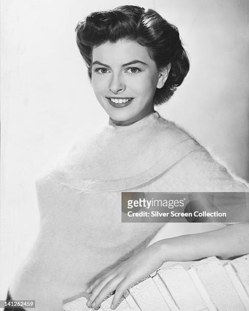Joan Rice , British actress, wearing a white angora jumper, smiling in a studio portrait, against a white background, circa 1955.