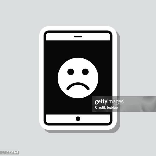 tablet pc with sad emoji. icon sticker on gray background - disappointing phone stock illustrations