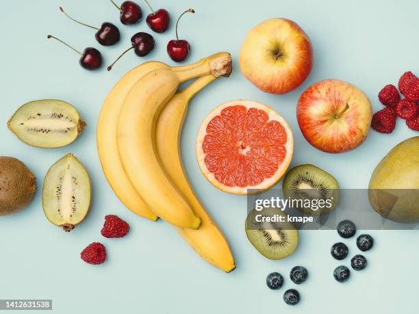 fruit flat lay layout colorful photo of fresh banana grapefruit berries and apples - apple fruit stock pictures, royalty-free photos & images
