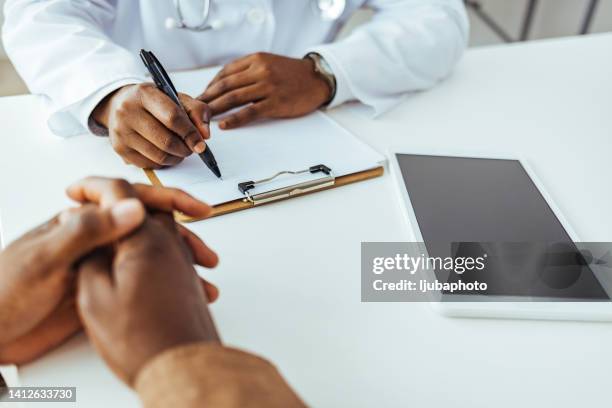 male doctor hand holding pen while filling patient history list - patient history stock pictures, royalty-free photos & images