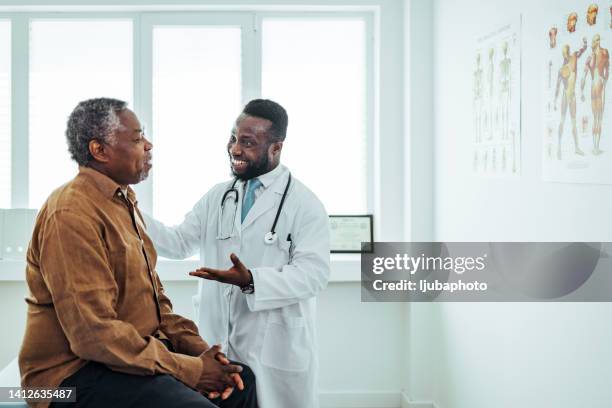 a male doctor chats to an elderly male patient. - sexo masculino imagens e fotografias de stock