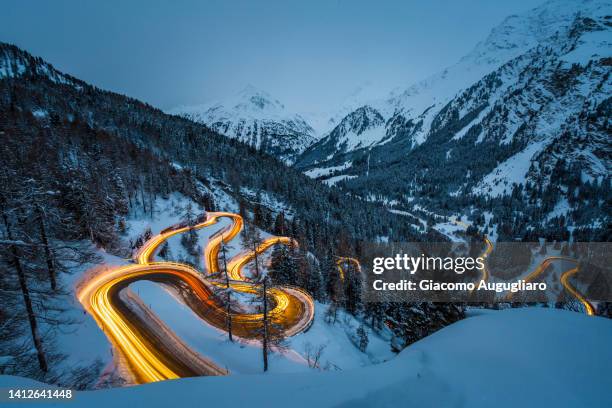 car light trails on a winding road in winter, maloja pass, switzerland - região de maloja - fotografias e filmes do acervo