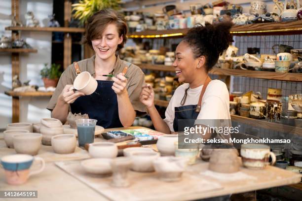 paint ceramics cup at ceramics workshop with an instructor. - female friendship painting stock pictures, royalty-free photos & images
