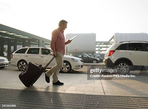 business traveller checks digital tablet, airport - milan airport stock pictures, royalty-free photos & images