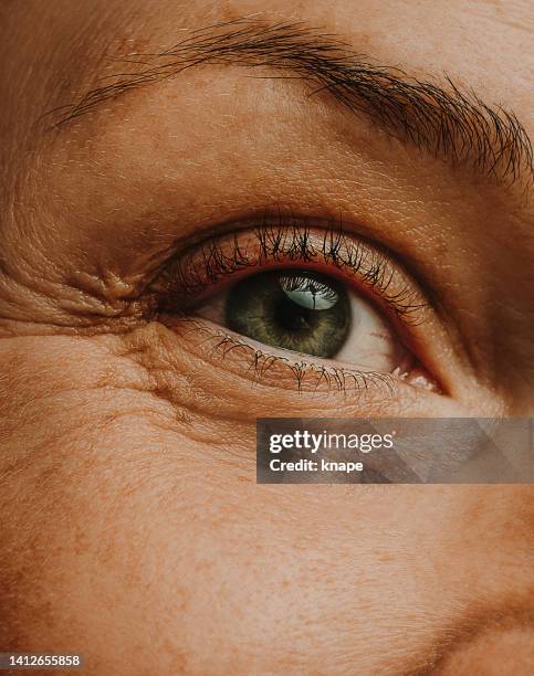mature woman adult eye skin and wrinkles macro close up - close up eye stockfoto's en -beelden