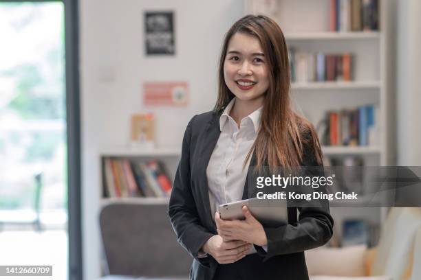 portrait of confident chinese businesswoman in office - mid adult stock pictures, royalty-free photos & images