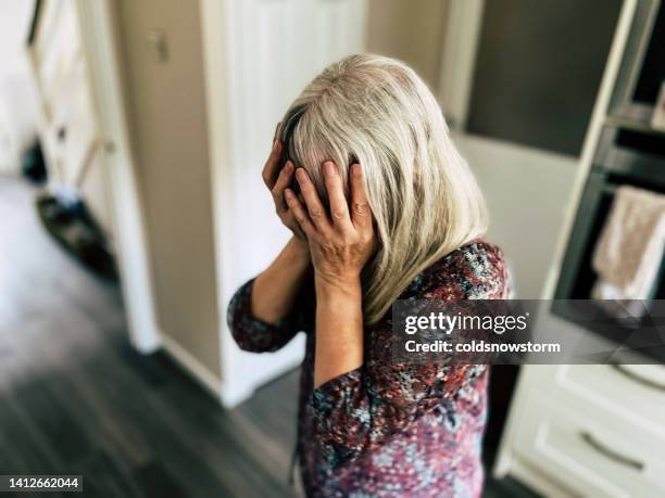 depressed woman with head in hands - home violence stock pictures, royalty-free photos & images