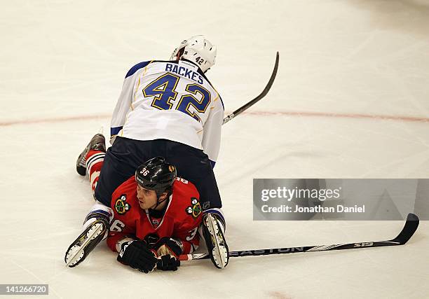 David Backes of the St. Louis Blues lands on top of Dave Bolland of the Chicago Blackhawks at the United Center on March 13, 2012 in Chicago,...