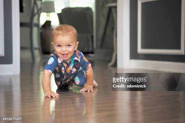happy eleven month old baby boy crawling - crawling stock pictures, royalty-free photos & images