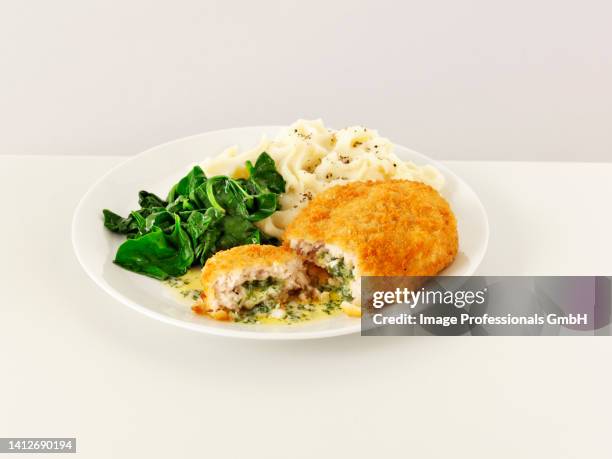 chicken kiev with mashed potatoes and spinach - chicken kiev stock-fotos und bilder
