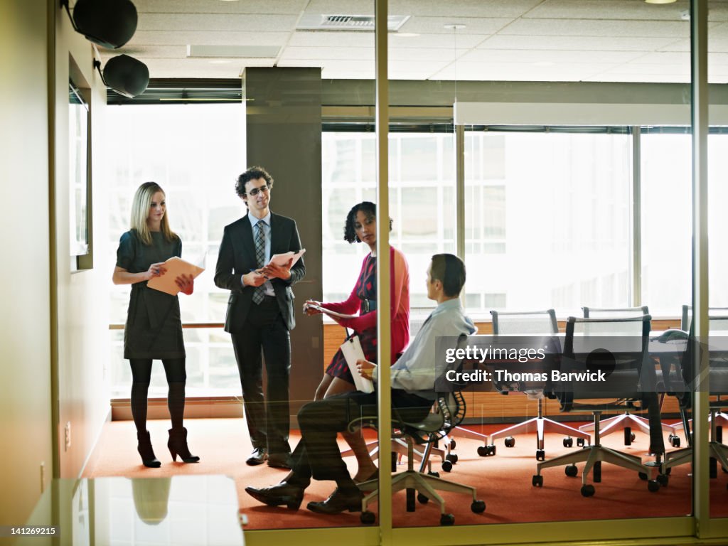 Coworkers discussing project in conference room