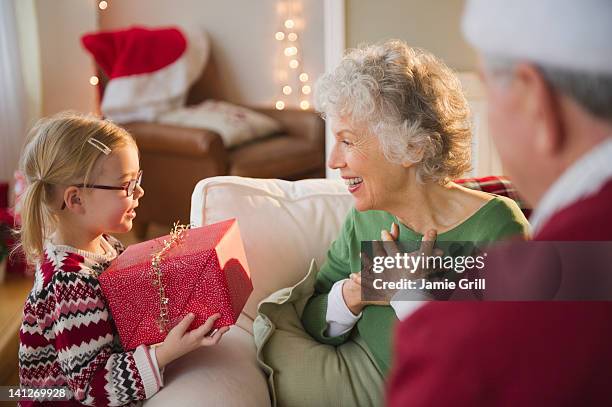 granddaughter giving christmas present to grandma - child giving gift ストックフォトと画像