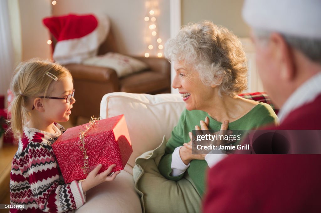 Granddaughter giving Christmas present to Grandma