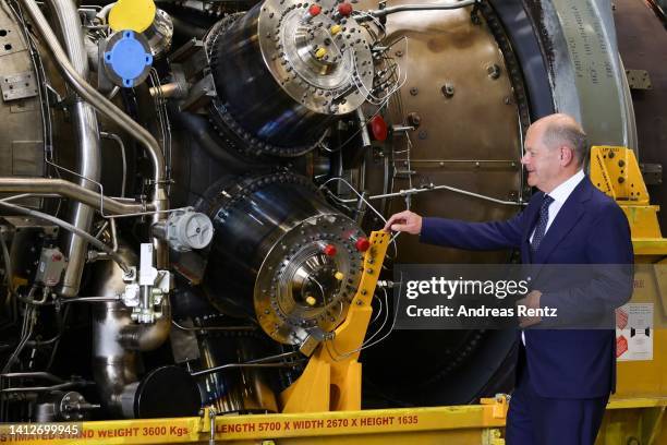 German Chancellor Olaf Scholz looks at the Siemens gas turbine intended for the Nord Stream 1 gas pipeline in Russia at a Siemens Energy facility on...