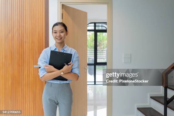 japanese female real estate agent standing in new house. - 不動産開発業者 ストックフォトと画像