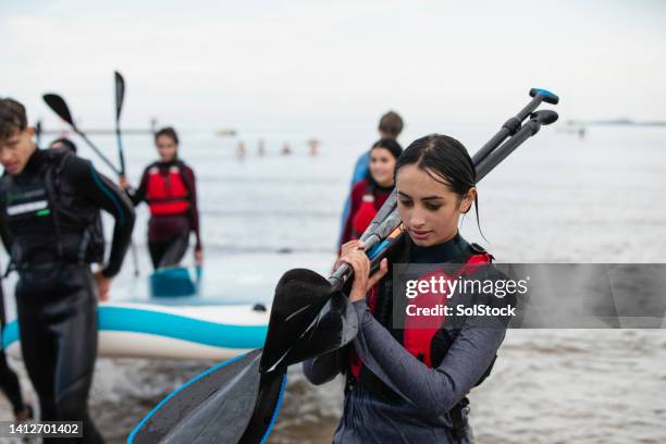 heading back after a day of paddle boarding - paddleboarding team stock pictures, royalty-free photos & images