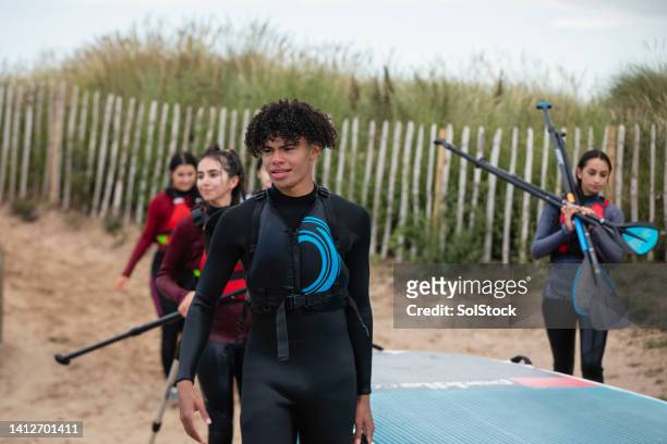 fun day of paddle-boarding at the beach - northumberland stock pictures, royalty-free photos & images