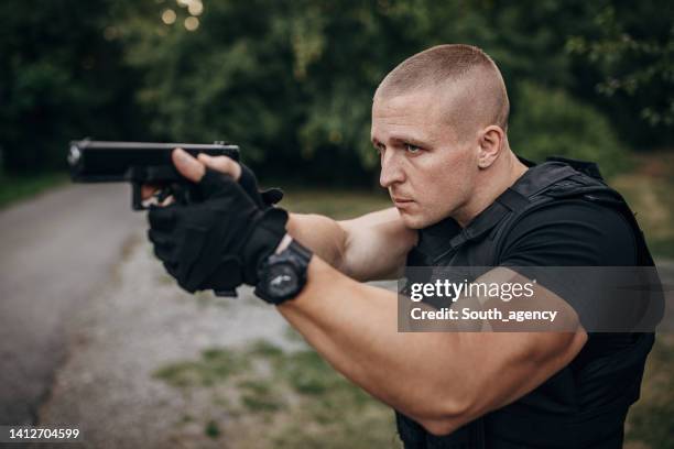 swat-team-soldat mit einer waffe - pistolenschießen stock-fotos und bilder