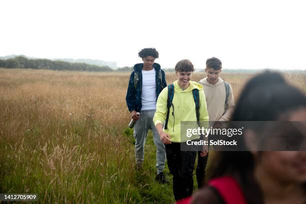 freunde auf einem gemeinsamen spaziergang - boys in countryside stock-fotos und bilder