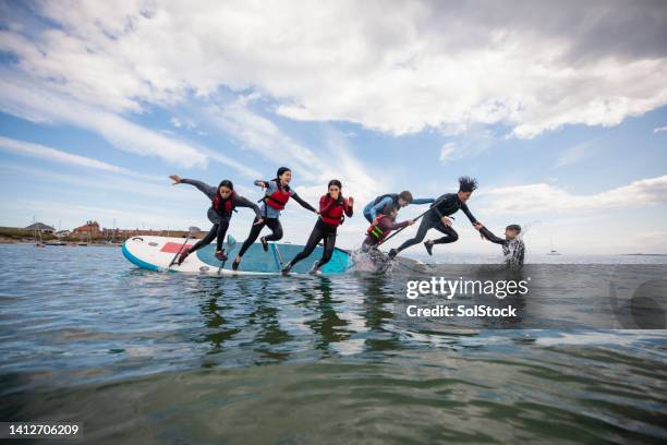 mischief with friends in the ocean - paddleboarding team stock pictures, royalty-free photos & images