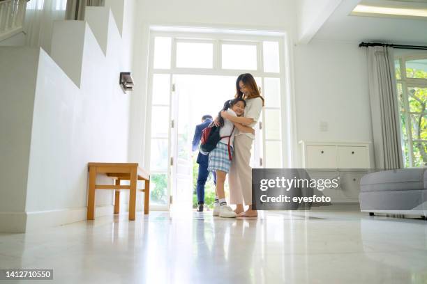 la mamma sta legando il laccio delle scarpe per la figlia prima di andare a scuola con il padre. - perfect asian girl foto e immagini stock