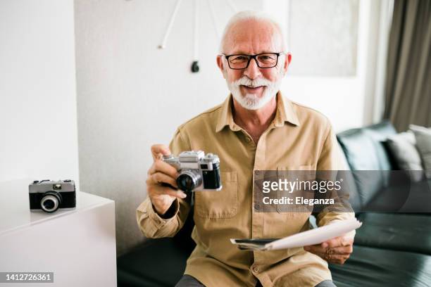 elderly man looking at his wedding picture, reminiscing of his late wife and the beautiful long life they've enjoyed together - old photographer imagens e fotografias de stock