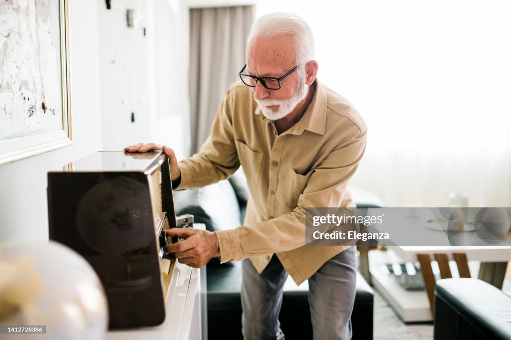 Senior male repairing an old radio receiver at home