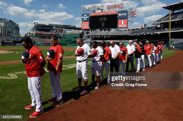Manager Dave Martinez and members of the Washington Nationals stand for a moment of silence for legendary Dodgers broadcaster Vin Scully before the...